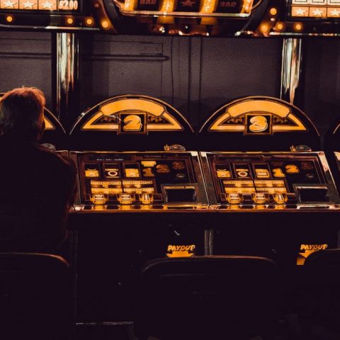 Seorang pria berjudi di mesin slot di sebuah arcade hiburan.